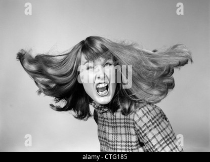 1960s ANGRY WOMAN YELLING GNASHING TEETH HAIR FLYING LOOKING AT CAMERA Stock Photo