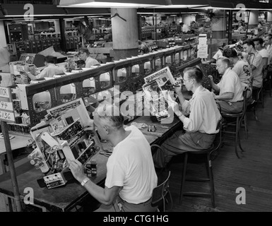 1950s MEN IN ELECTRONICS FACTORY WORKING ON TELEVISION ASSEMBLY LINE INDOOR Stock Photo