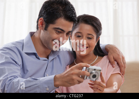 Loving young couple looking at digital camera together Stock Photo