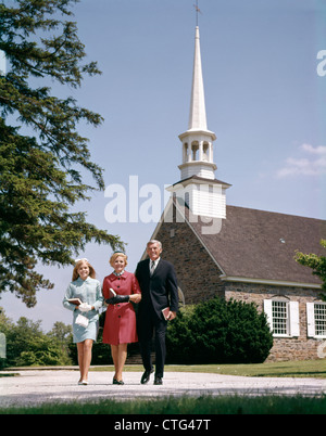 1960s SMILING FAMILY LEAVING CHURCH EACH CARRYING BIBLE Stock Photo