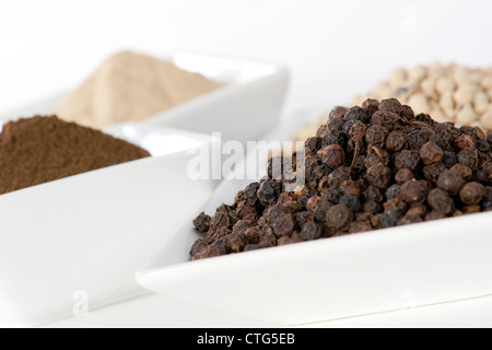 Black and white pepper grain and powder in ceramic bowl Stock Photo