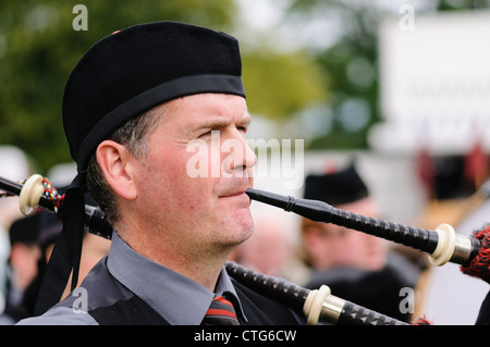 Piper playing a set of bagpipes Stock Photo