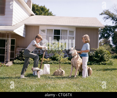 1960s 1970s BOY AND GIRL BROTHER AND SISTER MAKING SNOW MAN IN Stock