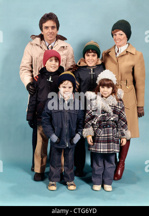 1970s FAMILY OF SIX PORTRAIT FULL LENGTH WEARING WINTER COATS LOOKING AT CAMERA Stock Photo