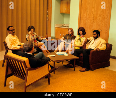 1960s 1970s GROUP MEN WOMEN SITTING AT COFFEE TABLE MEETING GROUP THERAPY Stock Photo