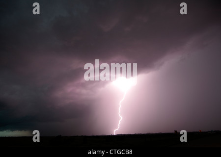 Lightning strikes behind a night squall line thunderstorm. Stock Photo