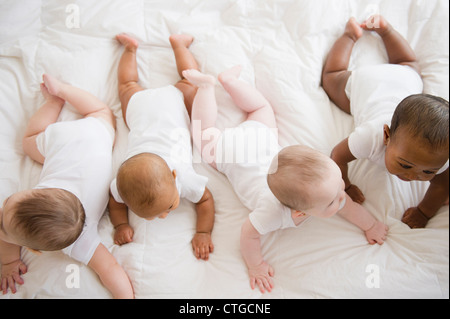 Babies laying on floor together Stock Photo