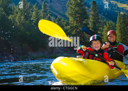 Caucasian father and son kayaking on river Stock Photo