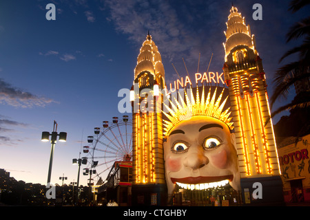 The entrance to Luna Park funfair at night, with the grinning face and ferris wheel Milsons Point Sydney NSW Australia Stock Photo