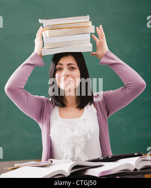 Caucasian student balancing books on head Stock Photo