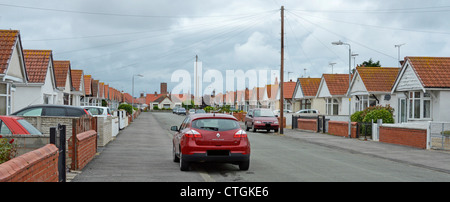 Street of many repetitive similar design bungalows with cars (obscured number plates) Stock Photo
