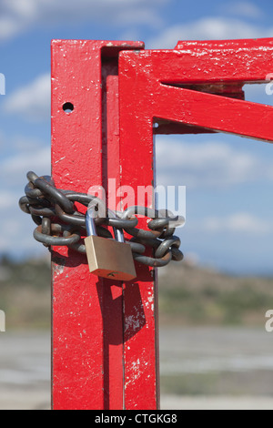 Chain and lock around red metal gate. Stock Photo
