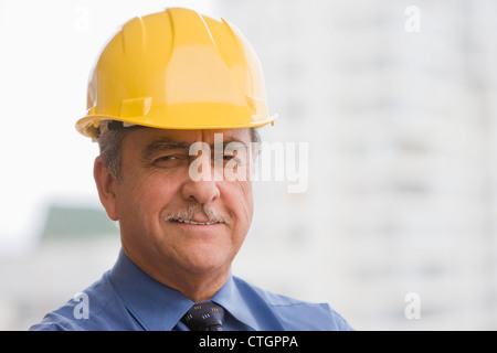 Hispanic businessman wearing hard hat Stock Photo