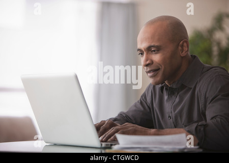 Black man typing on laptop Stock Photo