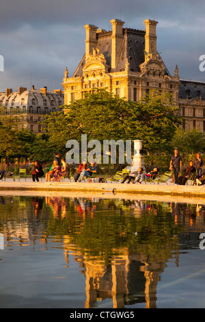 Relaxing at the pond in Jardin des Tuileries with Musee du Louvre beyond, Paris France Stock Photo