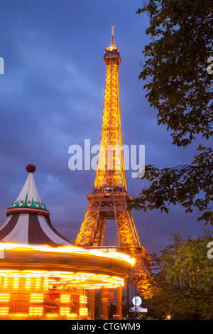 Carousel below the Eiffel Tower at twilight, Paris France Stock Photo