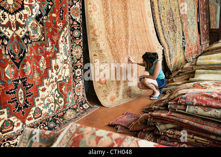 Woman shopping for an oriental carpet. Stock Photo