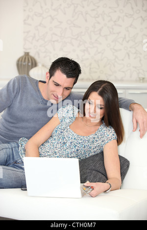 couple on couch with computer Stock Photo