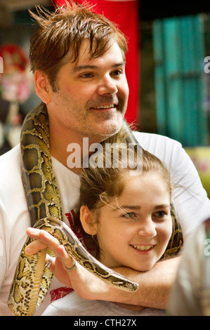 caucasian tourists posed with pythons snake in batu cave, kuala lumpur, malaysia. Stock Photo