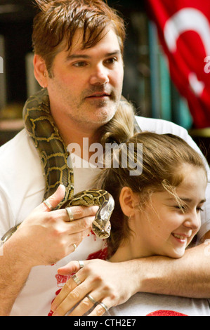 caucasian tourists posed with pythons snake in batu cave, kuala lumpur, malaysia. Stock Photo