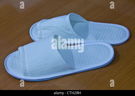 Stock Photo - A pair of white slippers on a Brown background Stock Photo