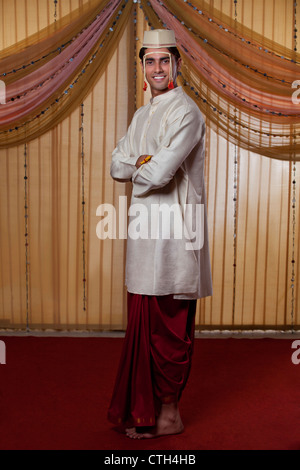 Full length of Indian groom smiling with arms crossed Stock Photo