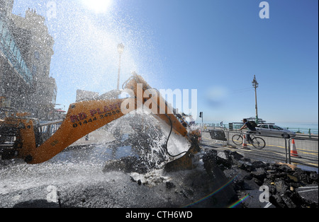 Water spouts out of the road at the bottom of Preston Street in Brighton after a JCB digger went through a mains pipe Stock Photo