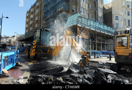 Water spouts out of the road at the bottom of Preston Street in Brighton after a JCB digger went through a mains pipe Stock Photo