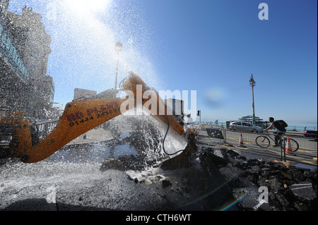 Water spouts out of the road at the bottom of Preston Street in Brighton after a JCB digger went through a mains pipe Stock Photo