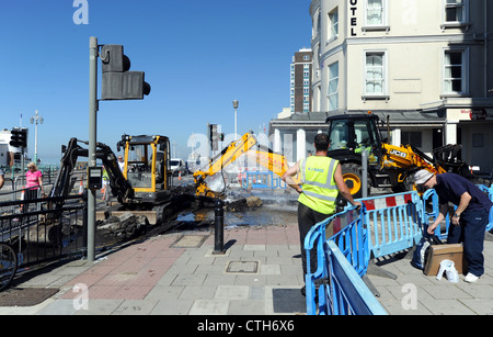 Water spouts out of the road at the bottom of Preston Street in Brighton after a JCB digger went through a mains pipe Stock Photo