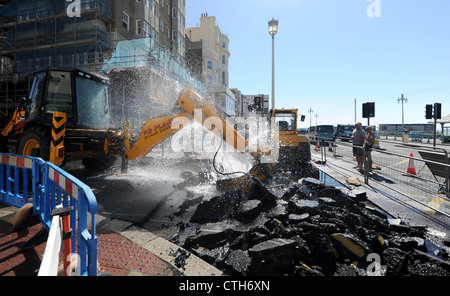 Water spouts out of the road at the bottom of Preston Street in Brighton after a JCB digger went through a mains pipe Stock Photo