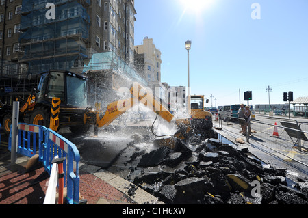 Water spouts out of the road at the bottom of Preston Street in Brighton after a JCB digger went through a mains pipe Stock Photo