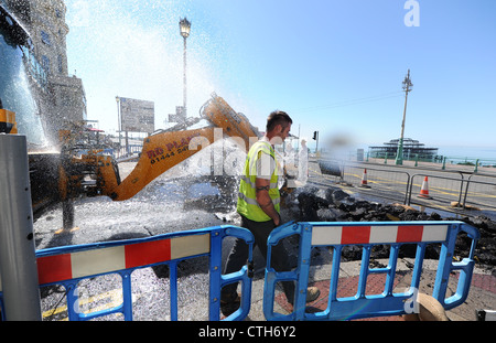 Water spouts out of the road at the bottom of Preston Street in Brighton after a JCB digger went through a mains pipe Stock Photo