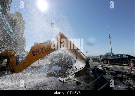 Water spouts out of the road at the bottom of Preston Street in Brighton after a JCB digger went through a mains pipe Stock Photo