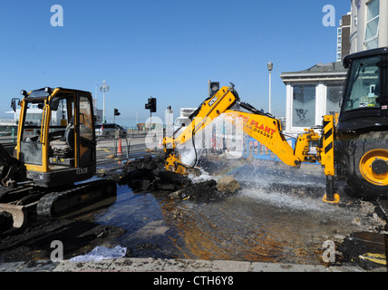 Water spouts out of the road at the bottom of Preston Street in Brighton after a JCB digger went through a mains pipe Stock Photo