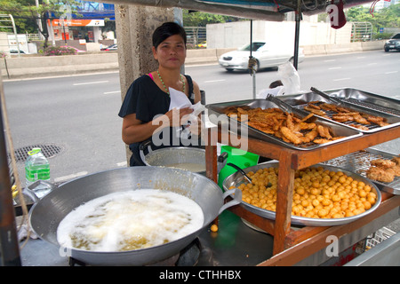 Street vendor using a wok to fry food in Bangkok, Thailand. Stock Photo