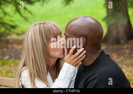 Interracial Married Couple Kissing In A Park; Edmonton, Alberta, Canada