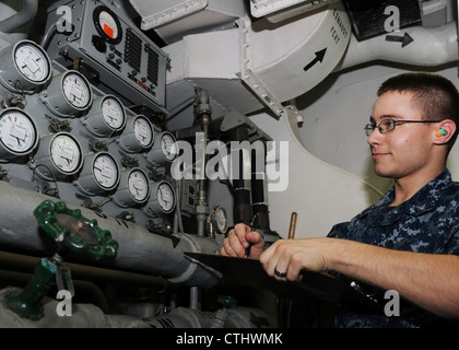 MachinistÕs Mate 3rd Class Justin Tracy, from Rapid City, S.D., takes routine readings for a high-pressure air compressor (HPAC) aboard the aircraft carrier USS Nimitz (CVN 68). Nimitz is underway participating in Rim of the Pacific (RIMPAC) 2012. Twenty-two nations, more than 40 ships and submarines, more than 200 aircraft and 25,000 personnel are participating in the RIMPAC exercise from June 29 to Aug. 3, in and around the Hawaiian Islands. RIMPAC is the worldÕs largest international maritime exercise. Stock Photo