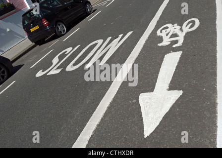 british road markings indicating that traffic should proceed slowly and a contra-flow cycle lane Stock Photo