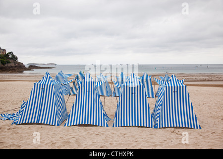 Blue and white striped beach huts on Dinard beach, Brittany, France Stock Photo