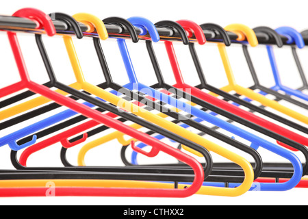 Empty plastic hangers on a rail with the focus on the fourth hanger, isolated on white background Stock Photo