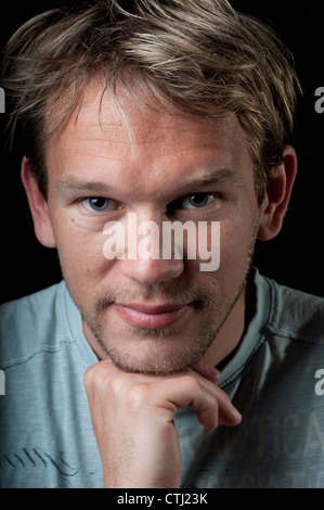Young man leaning on his hand Stock Photo