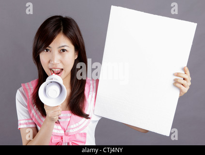 School girl screams via speaker and take white board. Stock Photo