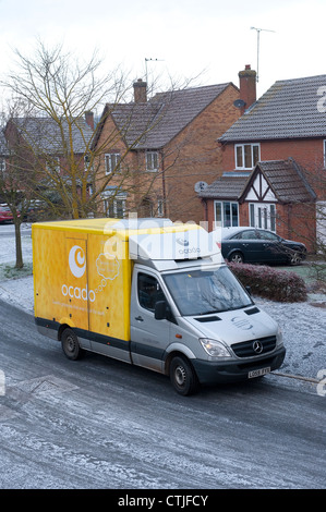 Ocado delivery van delivering groceries on a housing estate on a cold, wintery day in England. Stock Photo