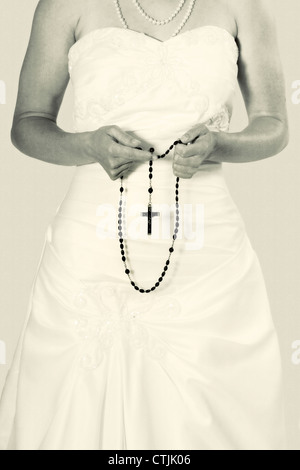 a woman holding a rosary in her hands Stock Photo