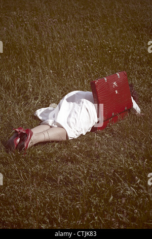 Woman lies in a red suitcase Stock Photo