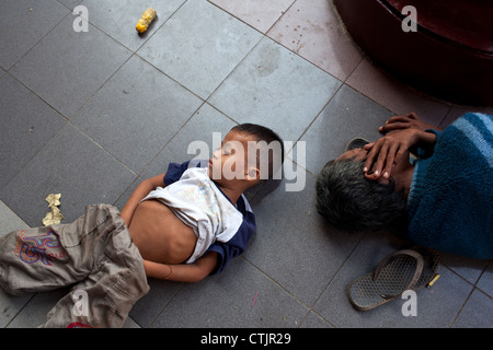 A young Burmese boy sleeps in one of the corridors leading to Shwedagon Pagoda, Yangon (Rangoon), Myanmar (Burma) Stock Photo