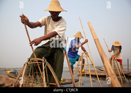 Burmese men at work doing traditional fishing on Inle Lake in Myanmar (Burma). Stock Photo