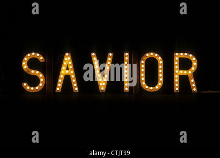 Savior written with light bulbs on a black background. Stock Photo