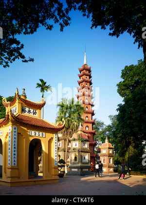 The Tran Quoc Pagoda towering by a temple beside West Lake. Stock Photo